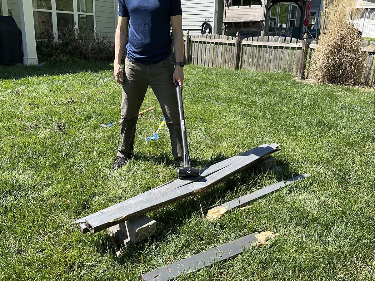 A person using one of the best sledgehammers to break apart fencing during testing