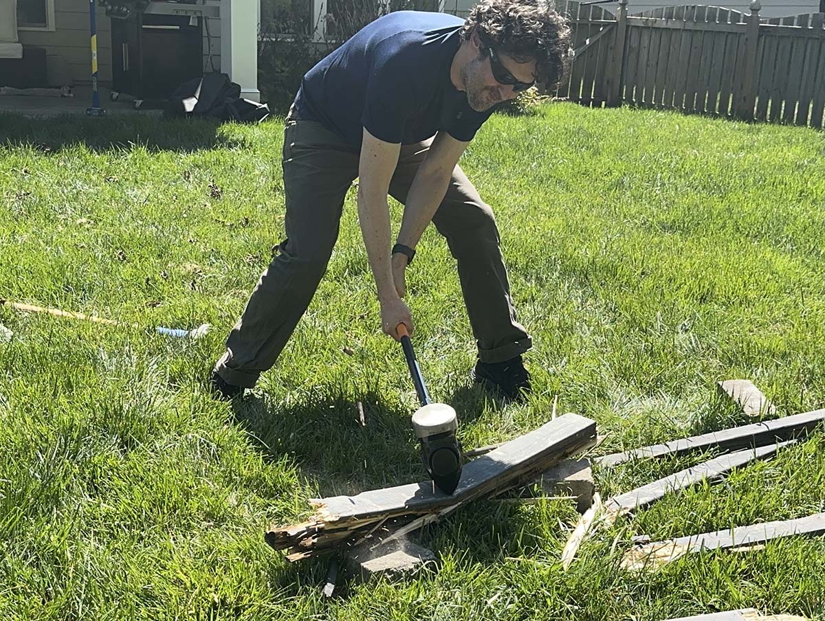 A person using one of the best sledgehammers to break apart fencing during testing