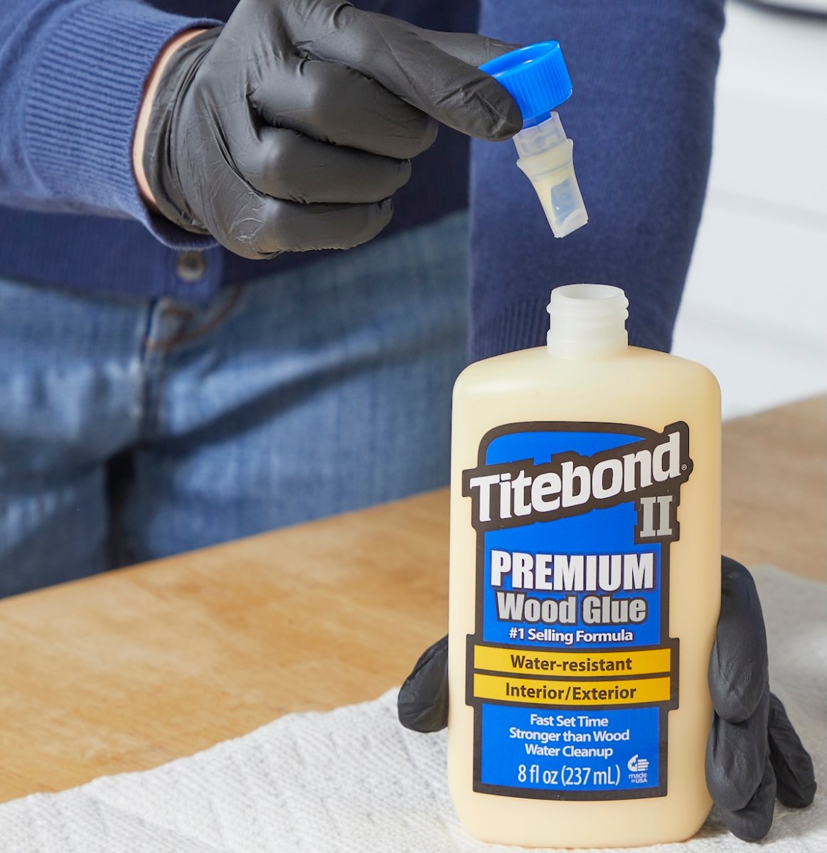Woman removes the cap from a bottle of Titebond wood glue.