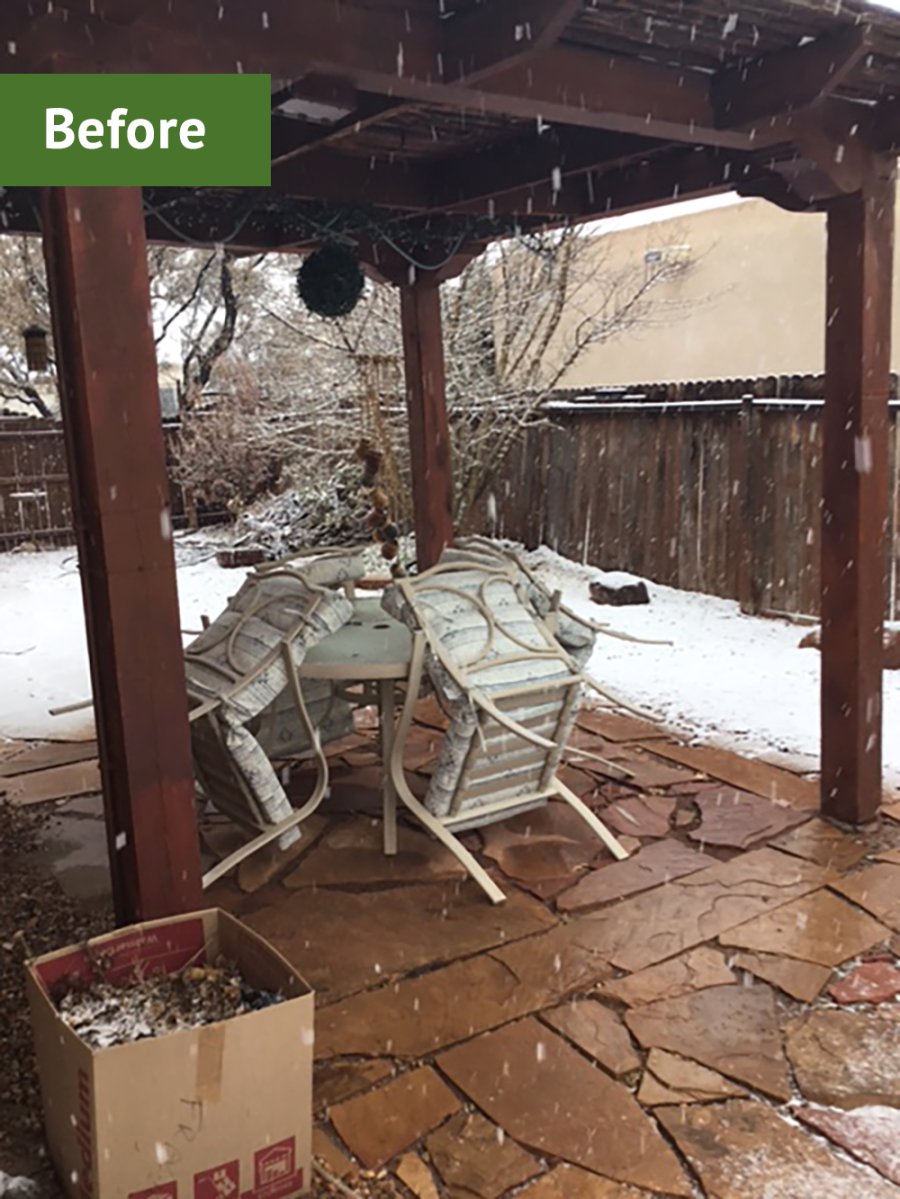 Old flagstone paver patio under a deck in a backyard.
