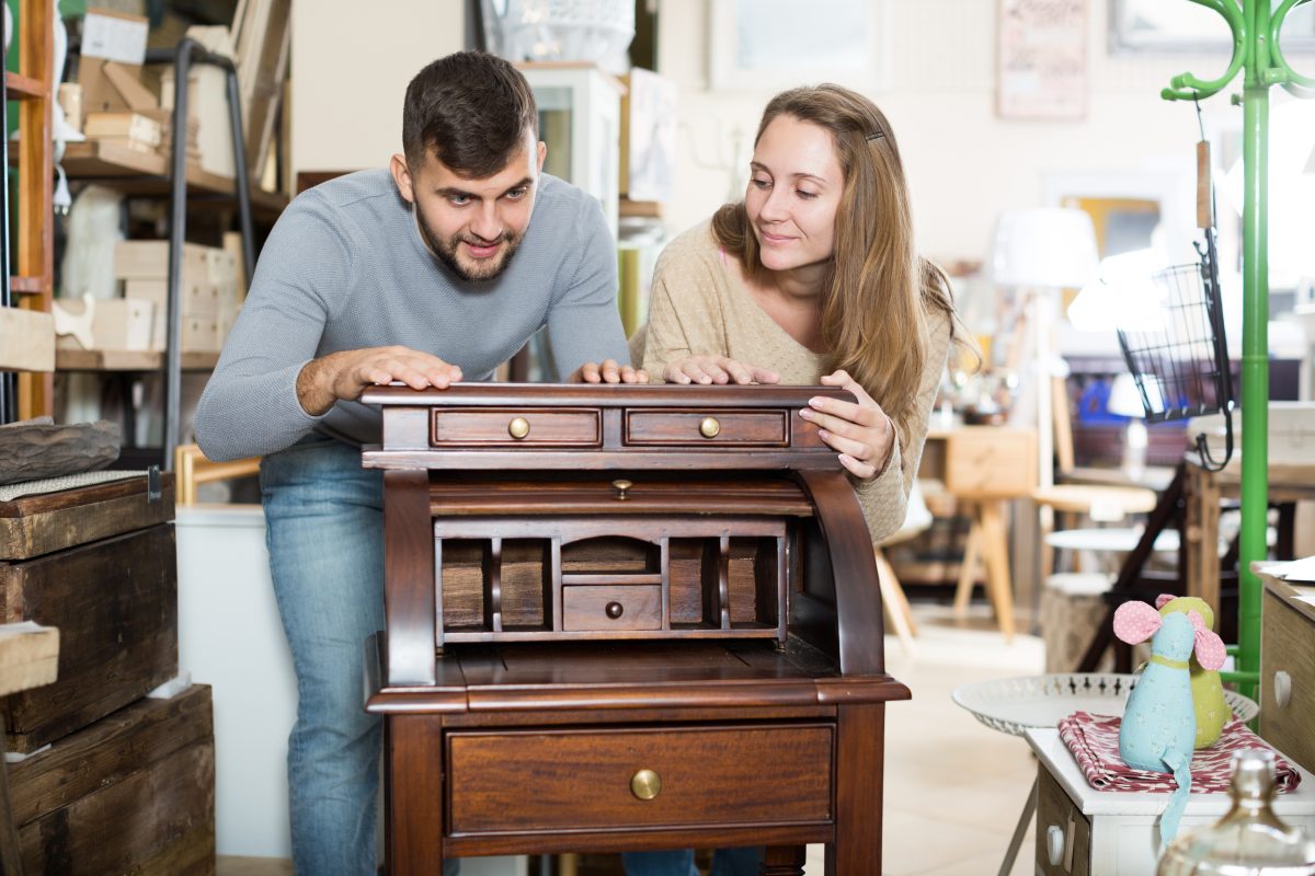Couple shopping for vintage cabinet in furniture store