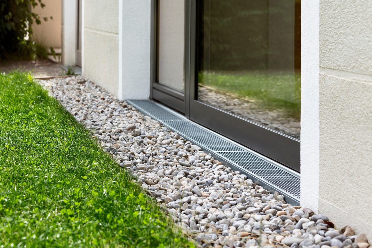 Drainage Stone Gravel around foundation of house in front of sliding glass door.