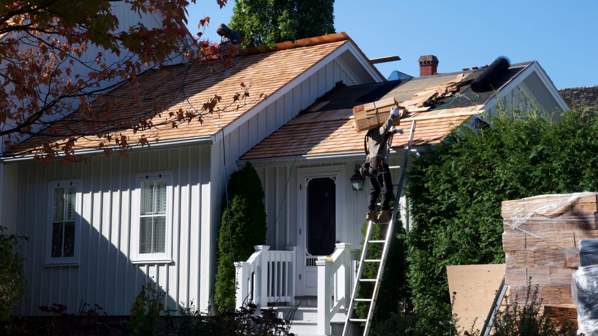 Construction workers installing a new roof on a house