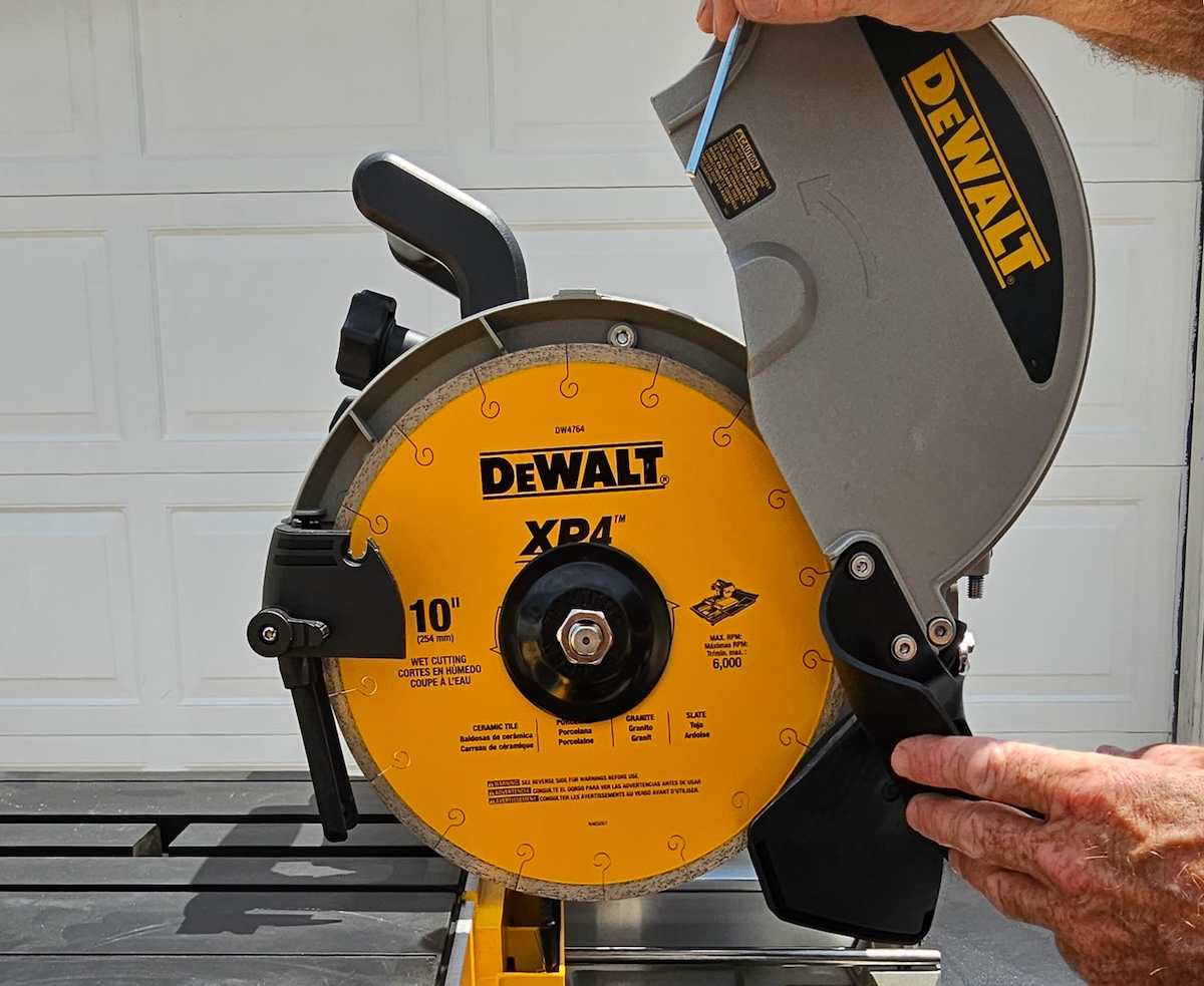 A person adjusts the blade on a wet saw.