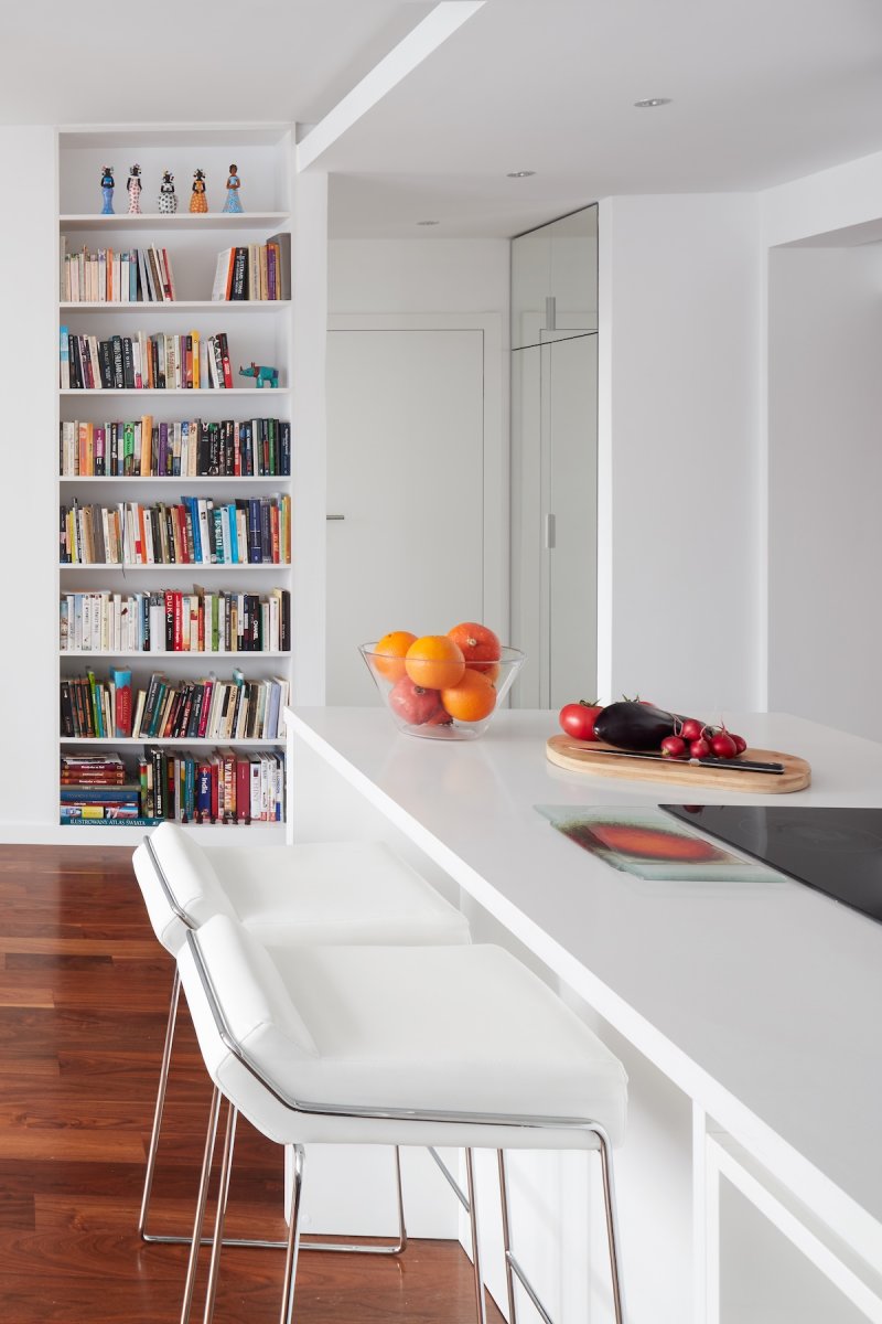 A modern home with a floor-to-ceiling library shelf in the kitchen.