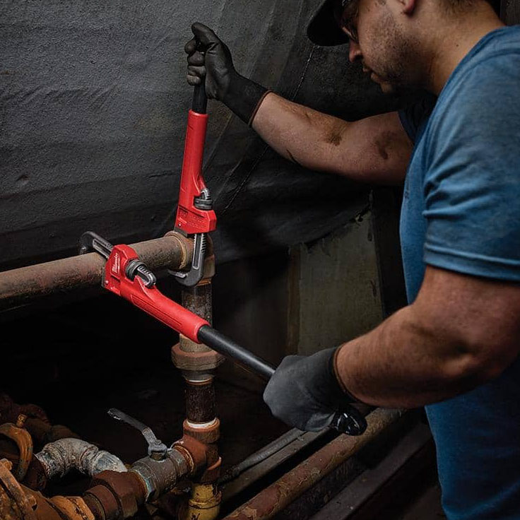 A person using the Milwaukee Cheater Pipe Wrench