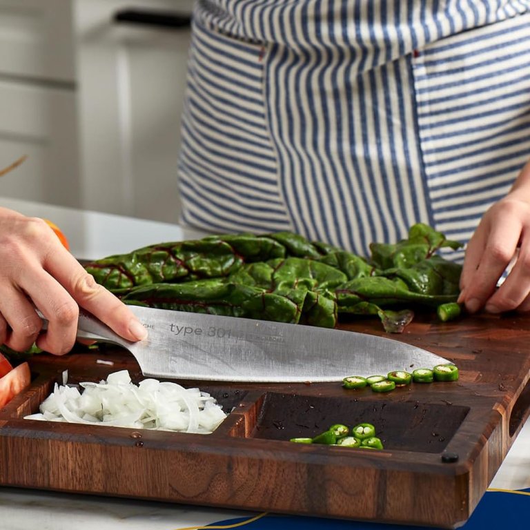 A person prepping vegetables on the Sonder Los Angeles Black Walnut Cutting Board