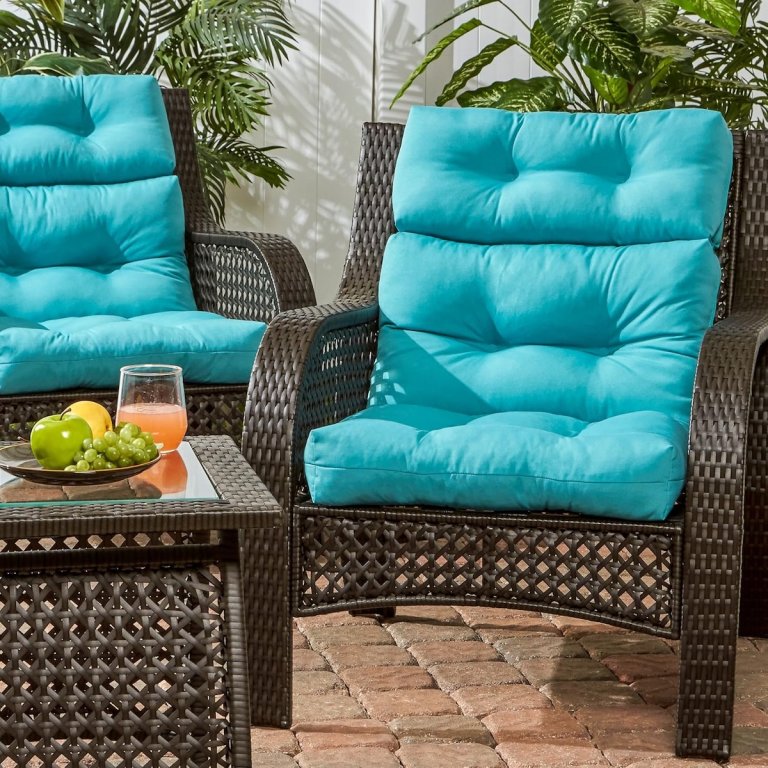 The Greendale Home Fashions High Back Outdoor Cushion on outdoor chairs next to a table with snacks and drinks