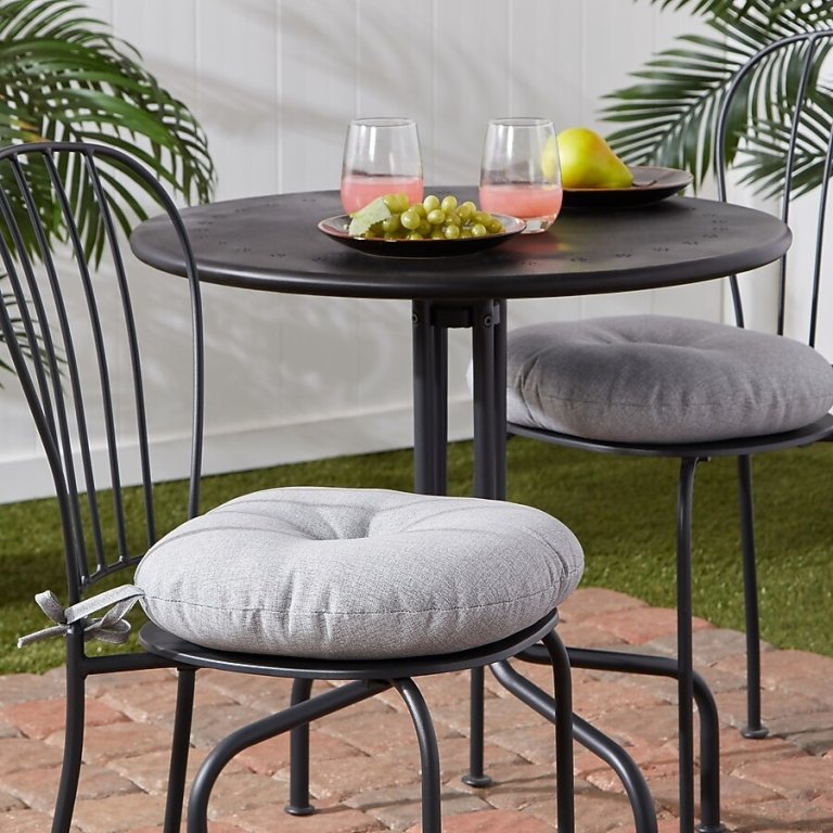 The Greendale Home Fashions Round Bistro Outdoor Cushion on bistro chairs next to a table