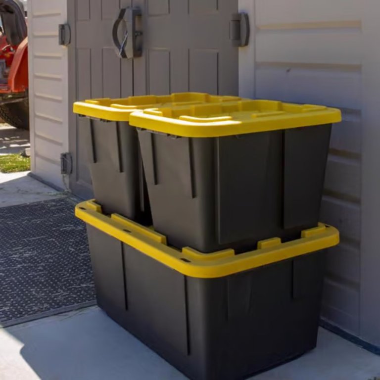 two Greenmade Pro Snap Lock Storage Boxes stacked on top of each other next to a shed