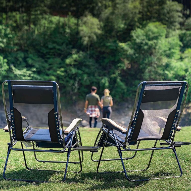 Two people walking across a large lawn with Portal Elite Mesh Zero-Gravity Loungers behind them