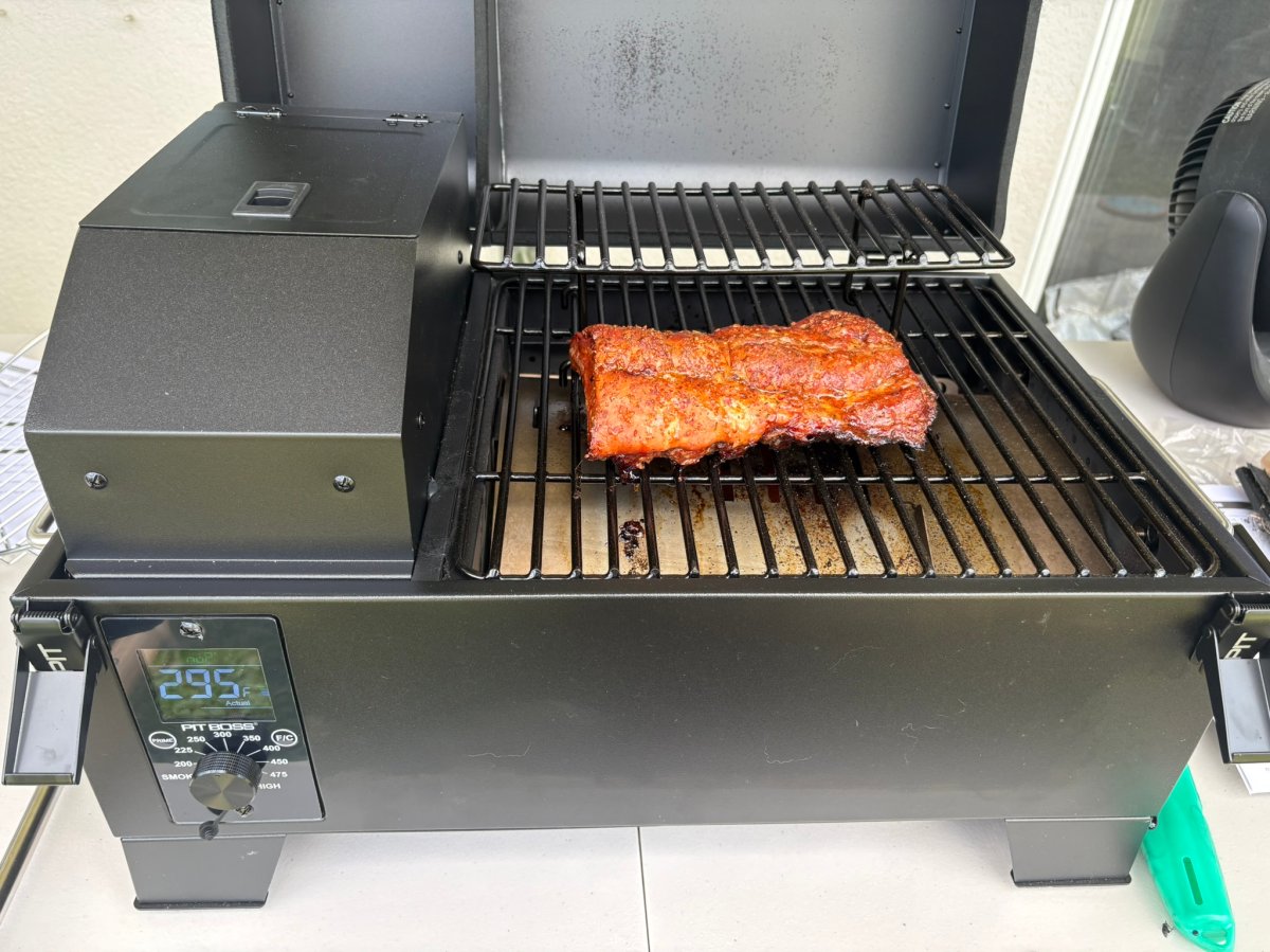 The Pit Boss Portable Tabletop Wood Pellet Grill with a piece of meat ready for smoking during testing