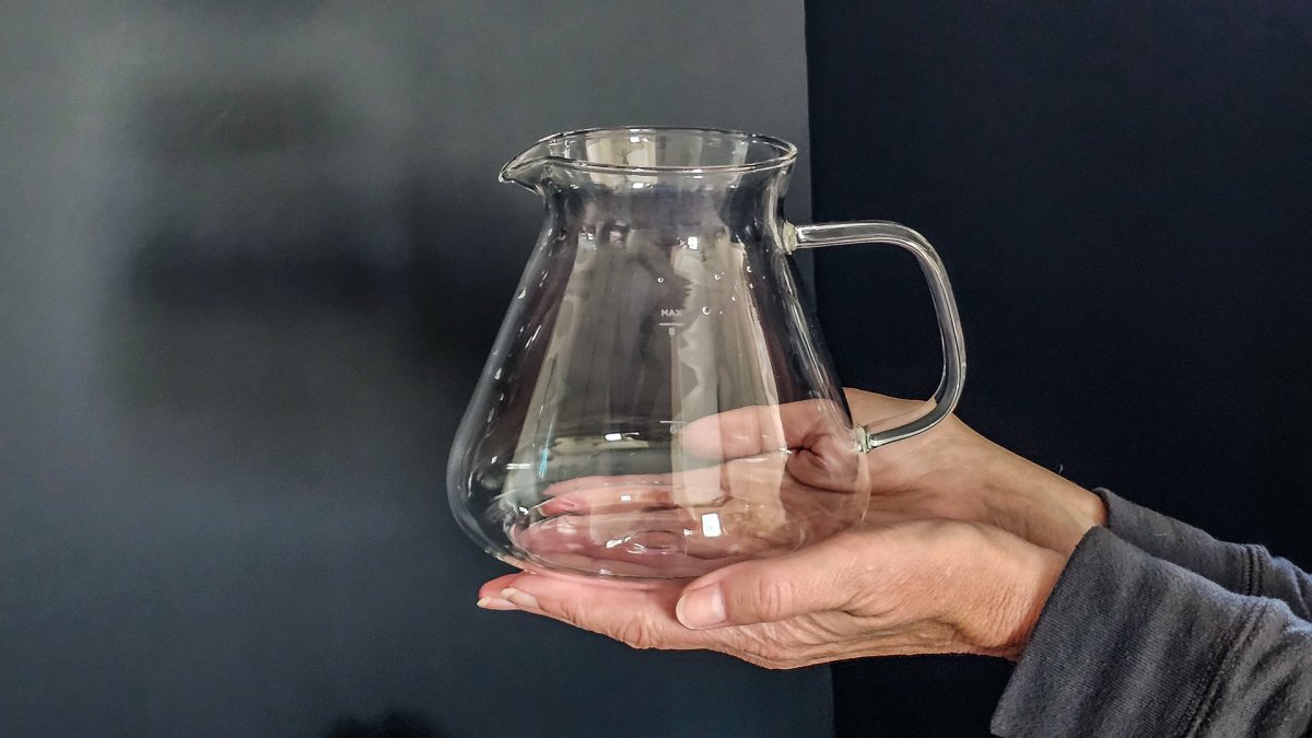 A product tester holding the SimplyGoodCoffee glass pitcher