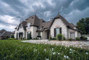 A large house with a HailGuard shingle roof protected from a hail storm.