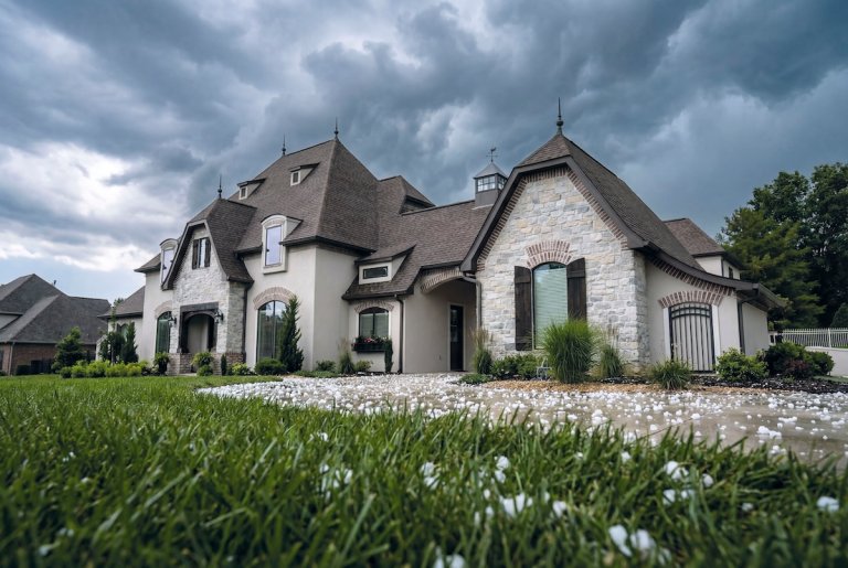 A large house with a HailGuard shingle roof protected from a hail storm.