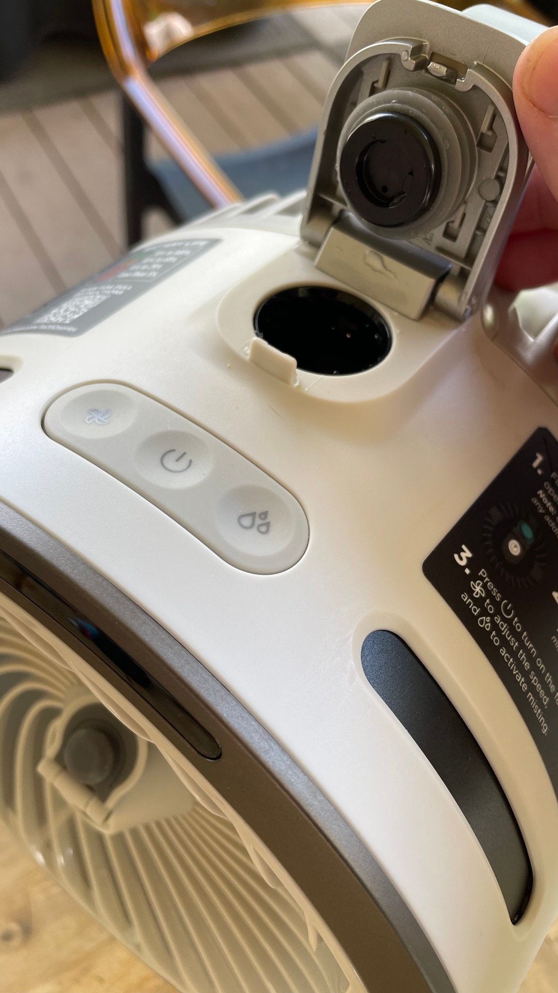 A person holding open the small door on the Shark FlexBreeze HydroGo Pro Fan for filling