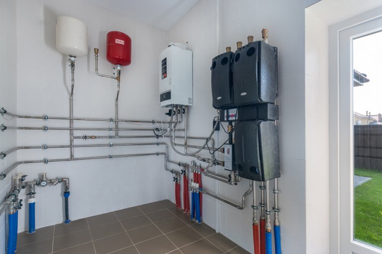 Modern equipment and complex wiring of pipes with sensors and switches in the interior of a mechanical closet.