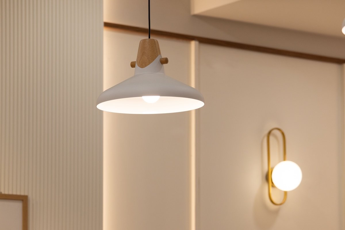 Ceiling light fixture and a wall-mounted sconce lighting up a room.