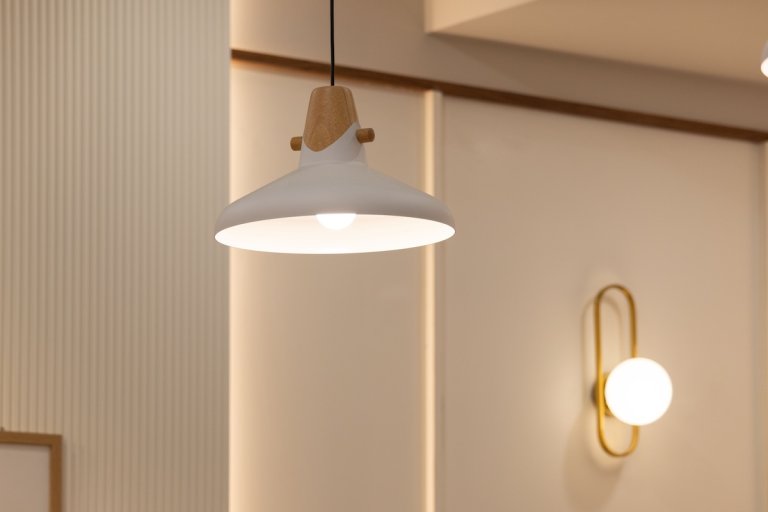 Ceiling light fixture and a wall-mounted sconce lighting up a room.
