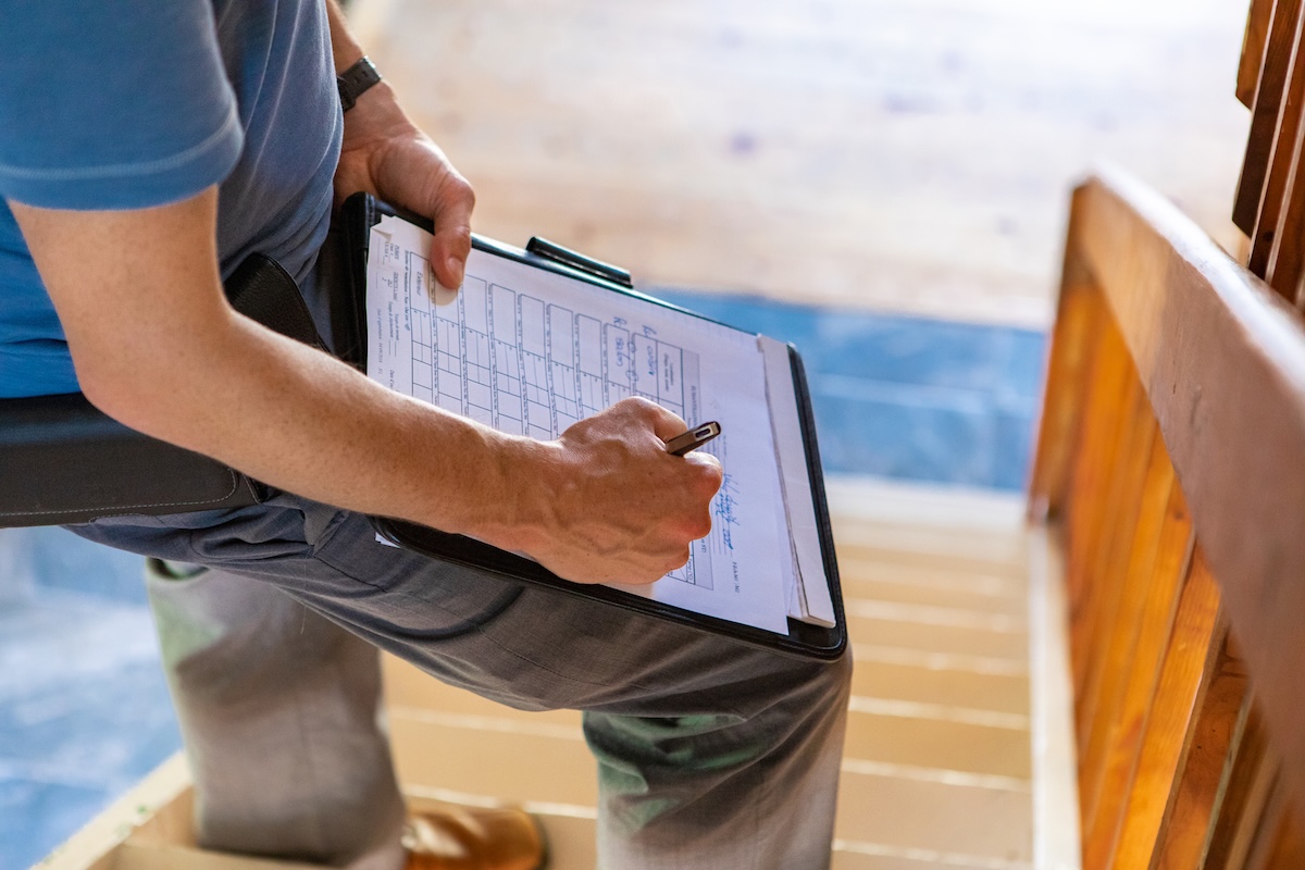 A home inspector writing a report on a deck.