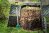 Layers of rotting compost in plastic composter bin in garden.