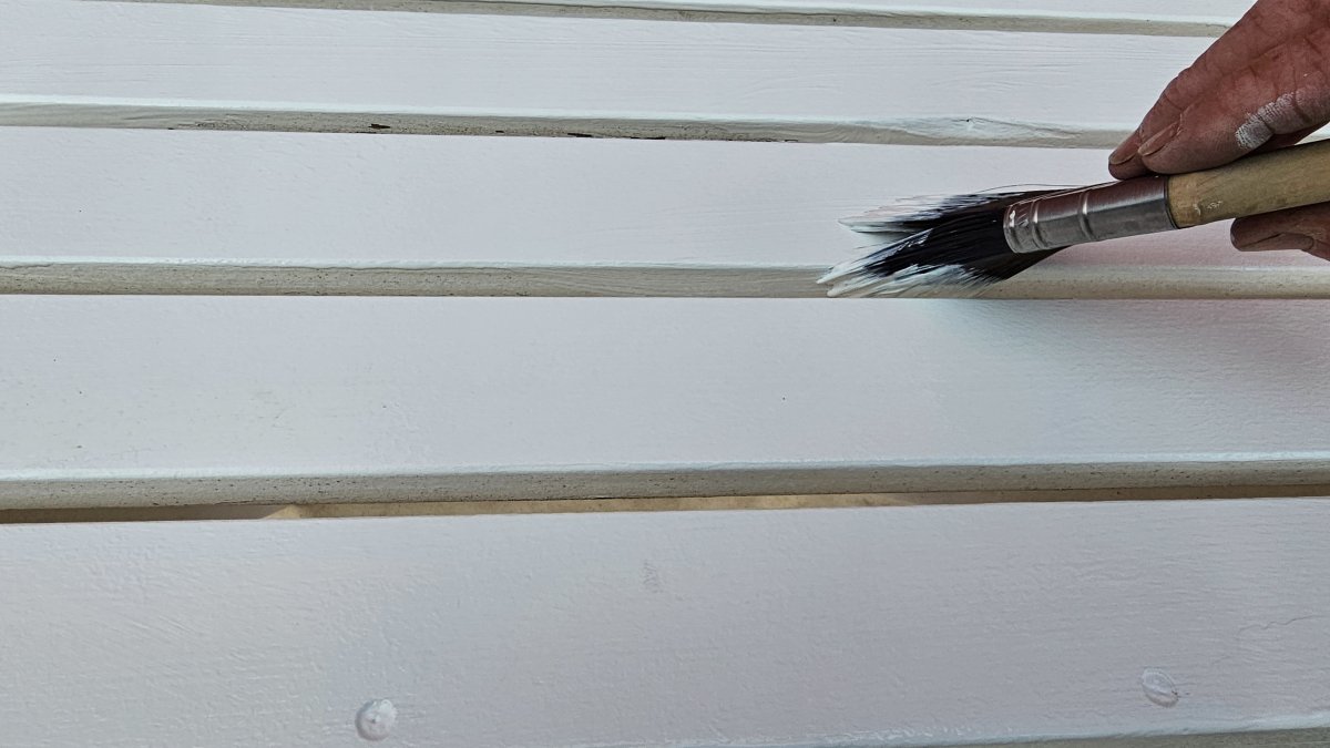 Brushing on Sherwin-Williams Forte Paint between slats