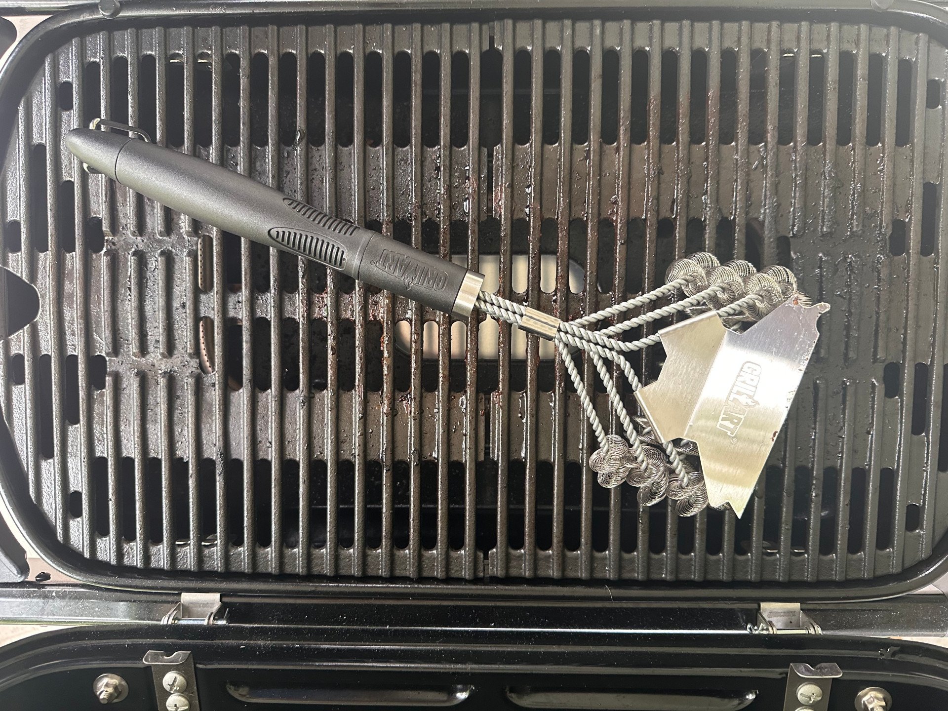 The GrillArt Bristle-Free 17-Inch Brush and Scraper on top of grill grates