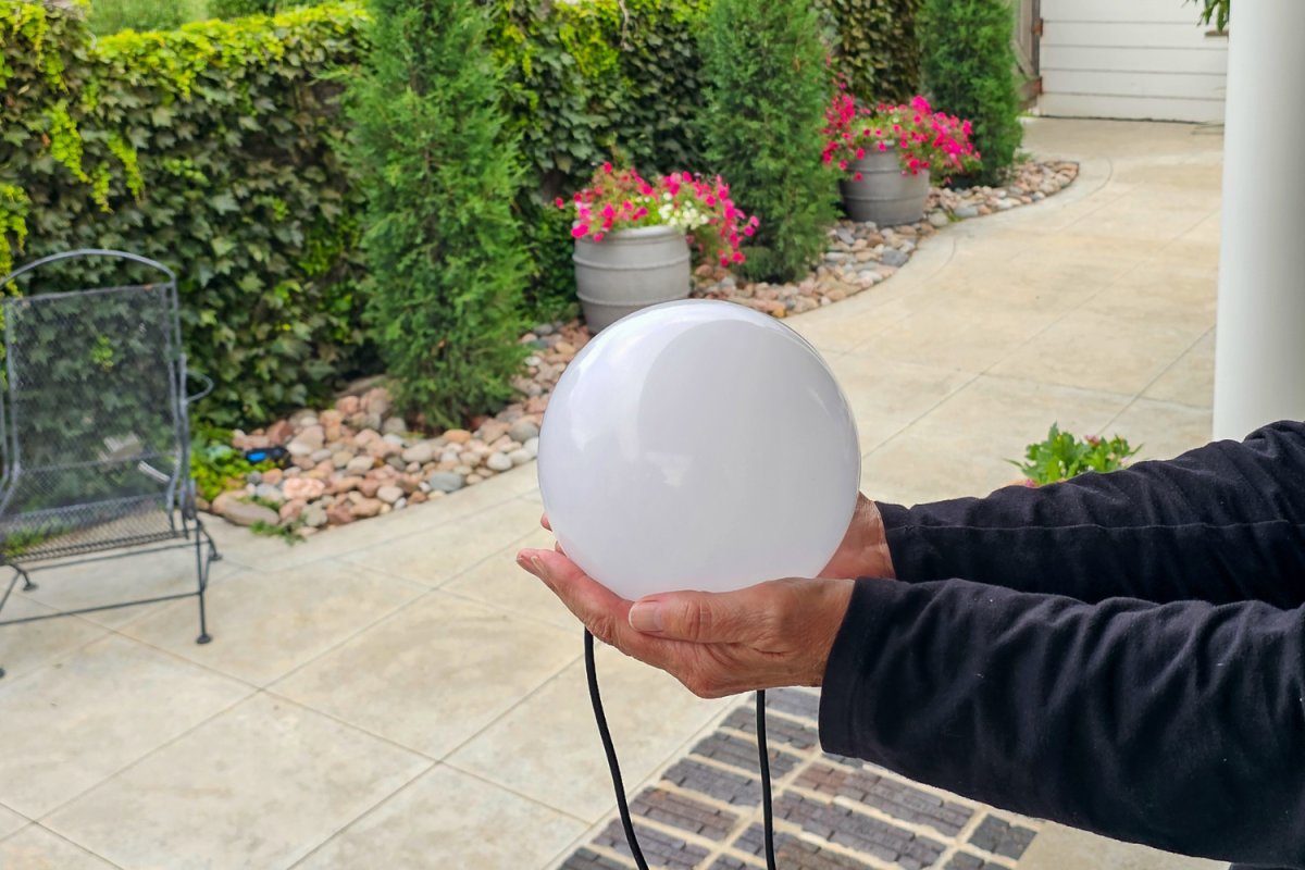 An Enbrighten large light sphere in a person's hands during testing
