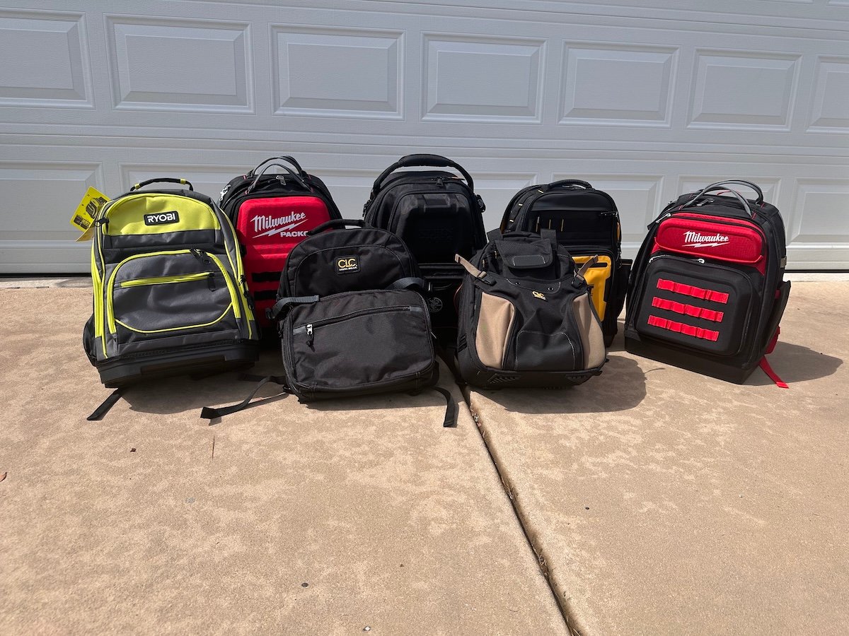 A group of the best tool backpacks in a driveway before testing