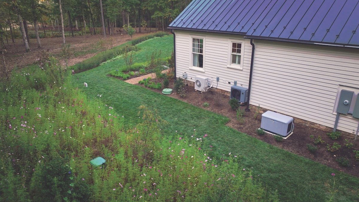 A residential home with underground propane storage tank and standby generator.