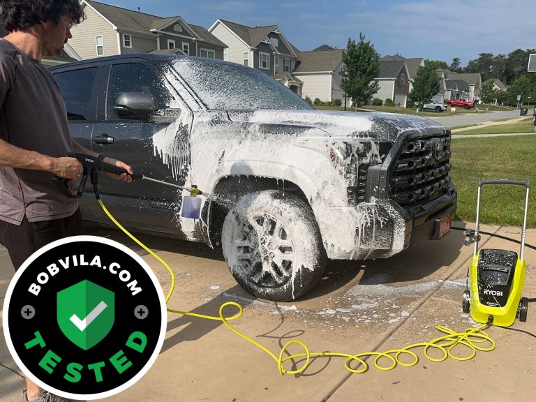 A person using the Ryobi RY142012 Pressure Washer to wash a car during testing