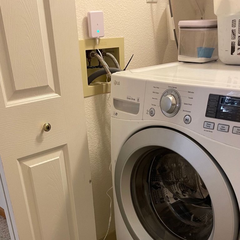 Shelly Flood Gen4 Smart Water Leak Detector installed next to a washing machine during testing