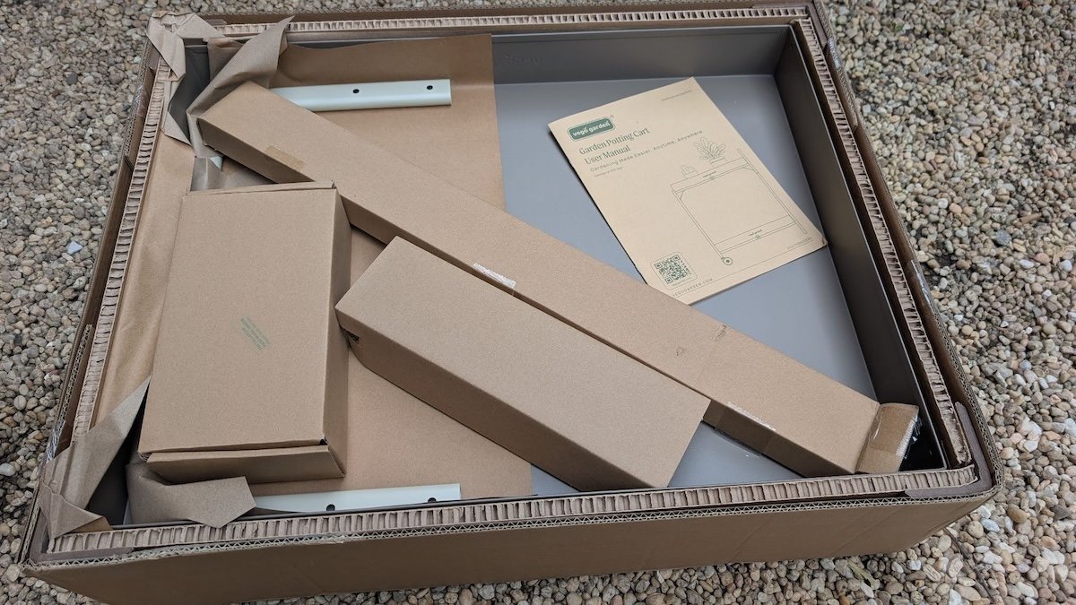 Pieces of the Vego Garden potting cart still covered in cardboard before assembly