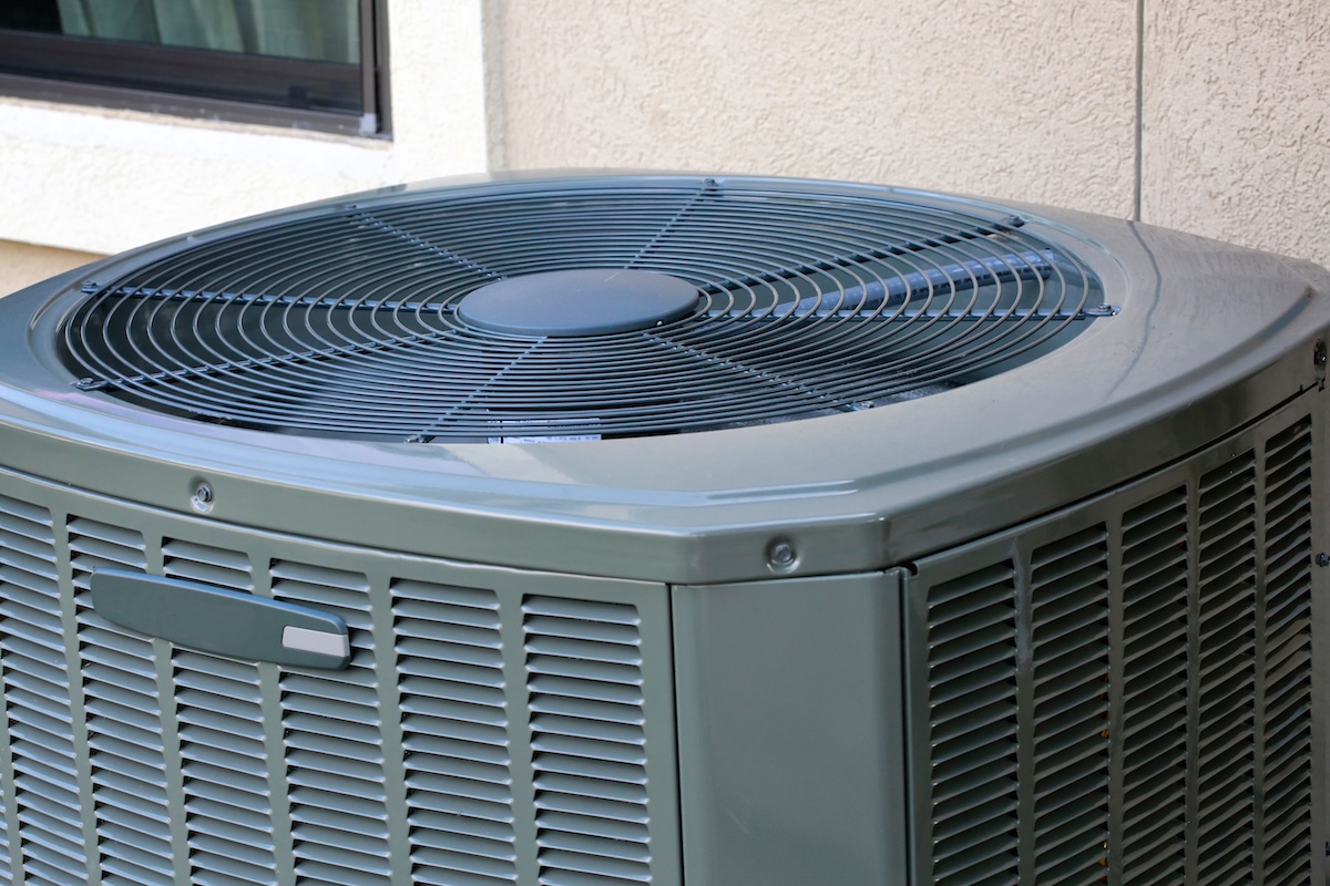 Close up of a modern AC compressor unit outdoors.