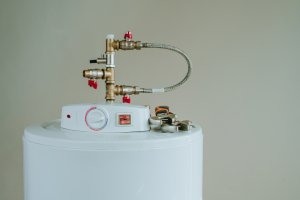 Top of water heater during with tools on top, on a beige background.
