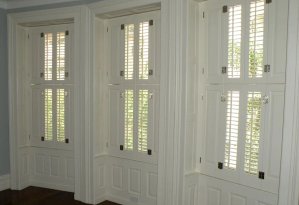 White top-to-bottom pocket shutters in a dining room.