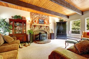 Living room of the farm house with wood ceiling and stone fireplace.
