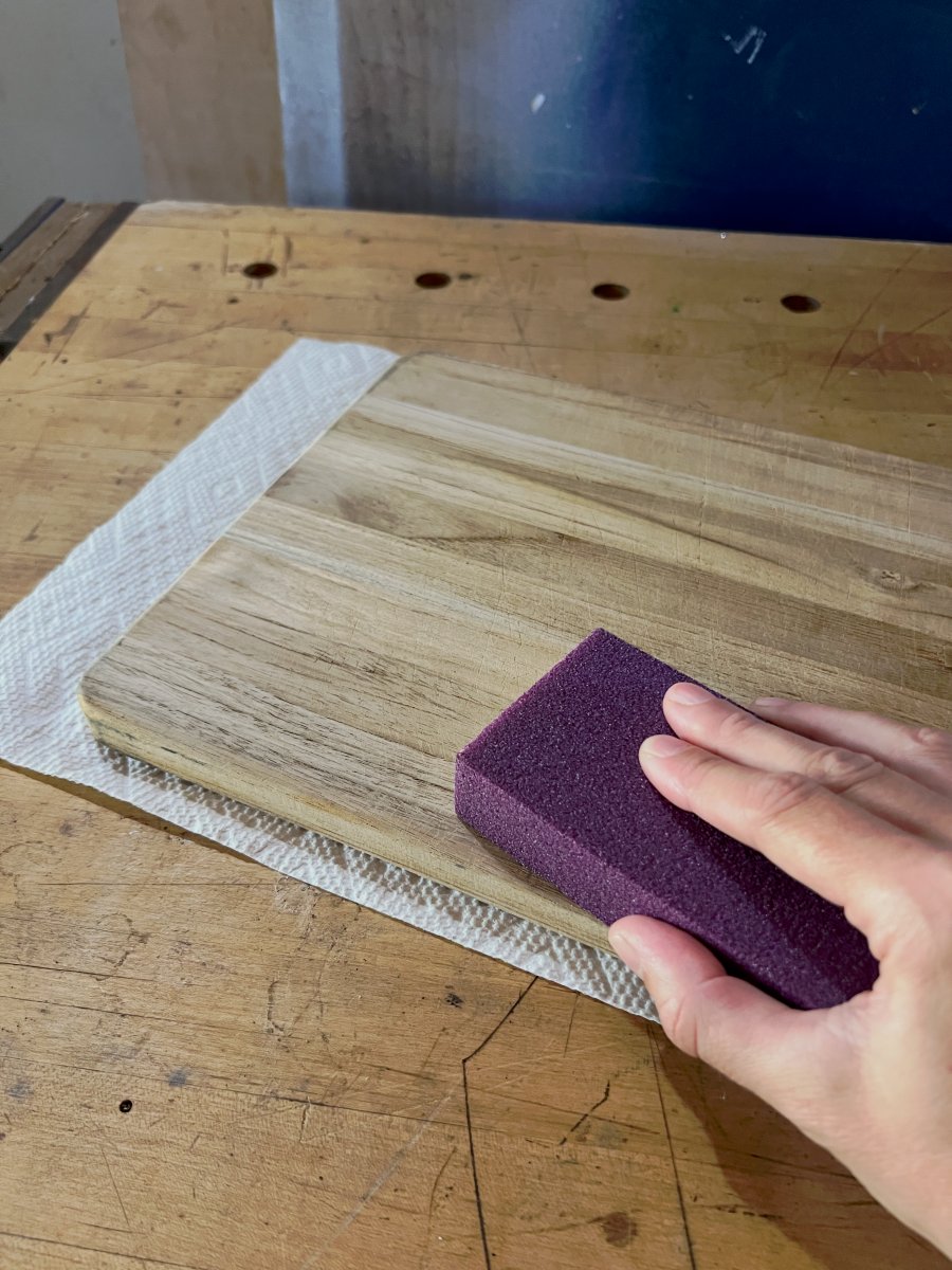 Sanding an old wood cutting board to restore it.