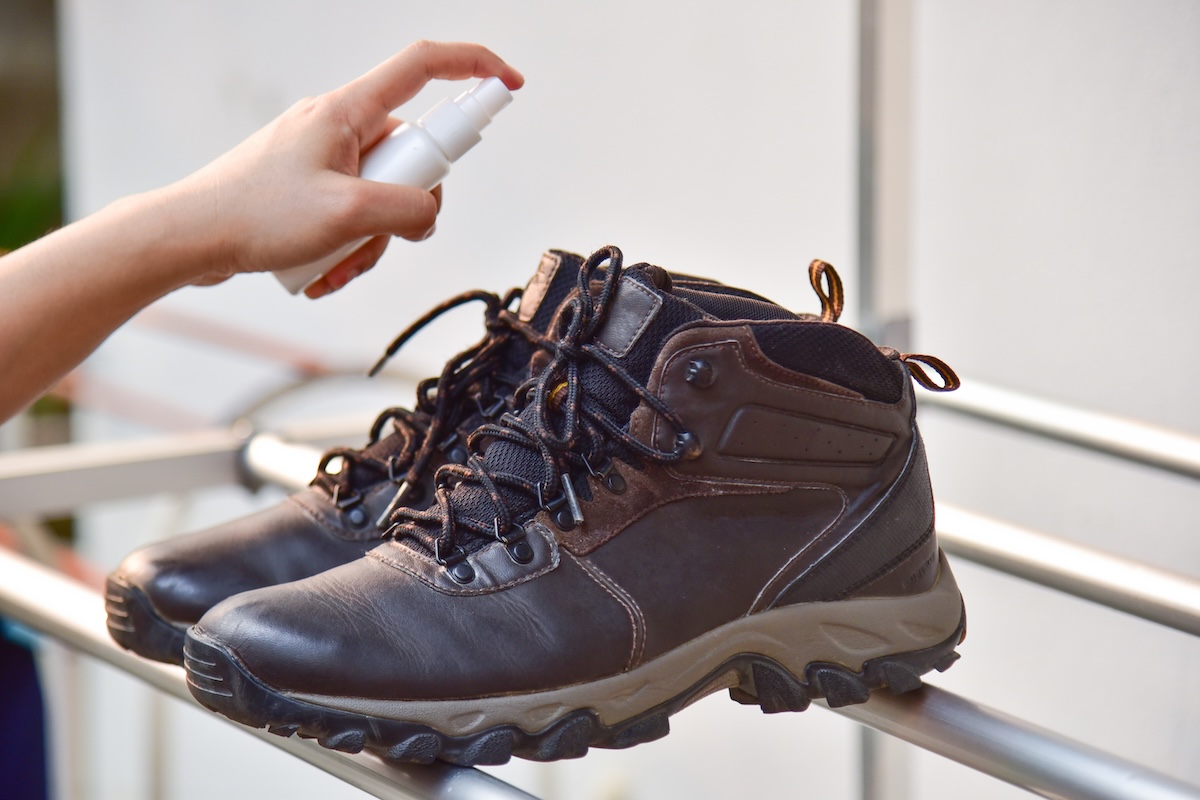 Spraying rubbing alcohol into smelly hiking boots. 