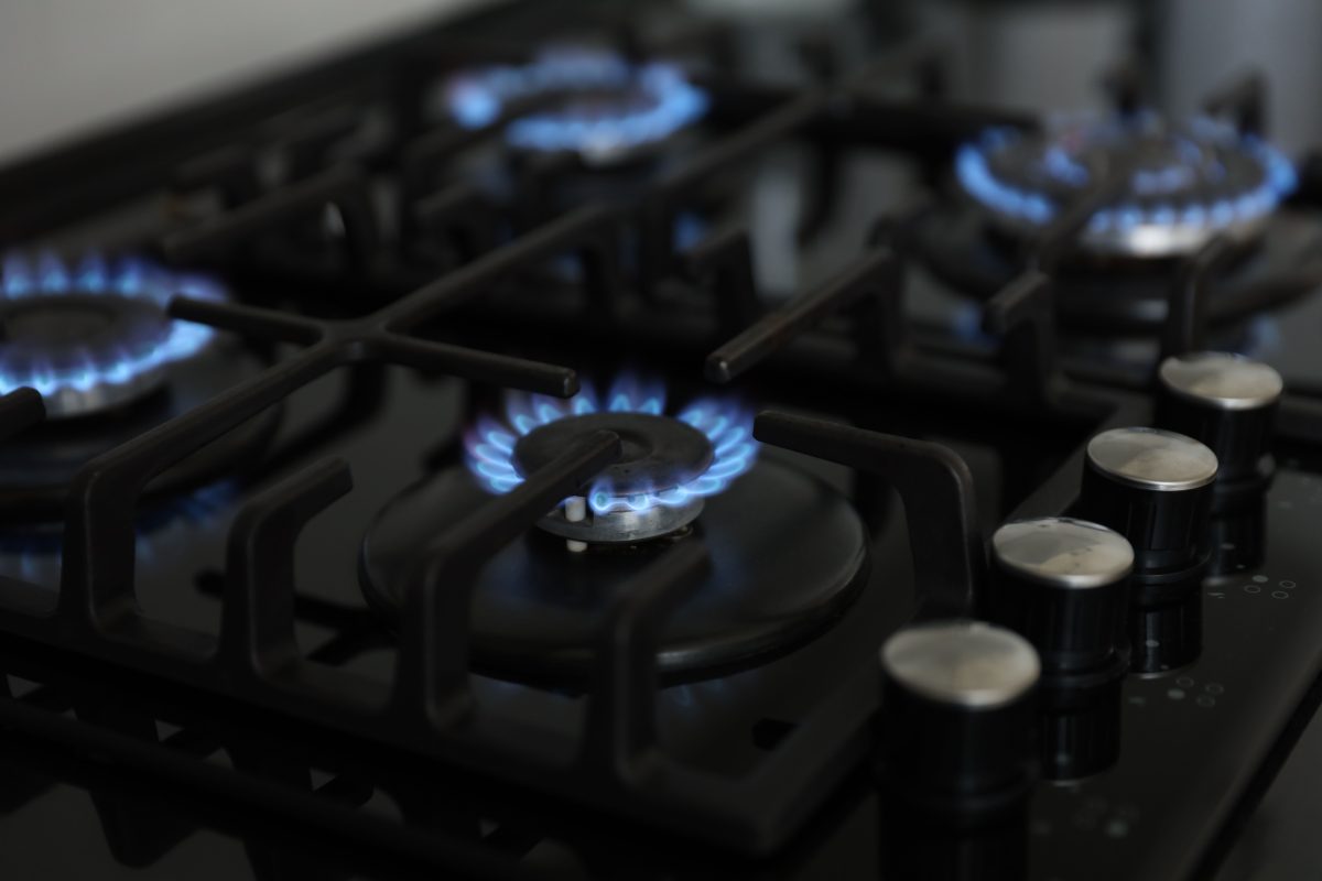Gas burners with blue flames on stove.