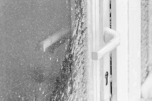 A white front door is covered with snow after a blizzard.