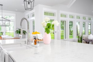 An all-white kitchen in a modern farmhouse with lots of transom windows