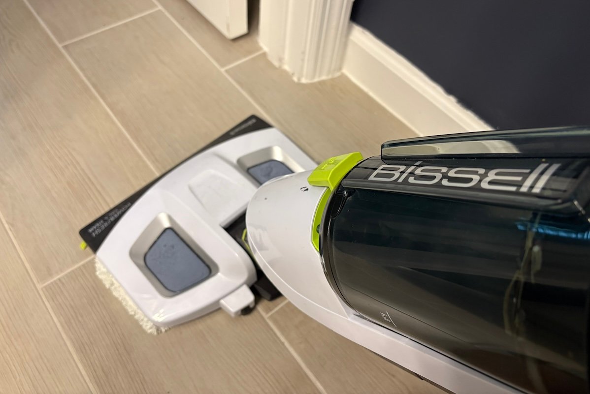 Bissel floor steamer cleans a light brown tile floor.
