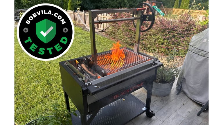 A large flame reaching up through the grates of the Blackstone Bronco Open Flame Grill