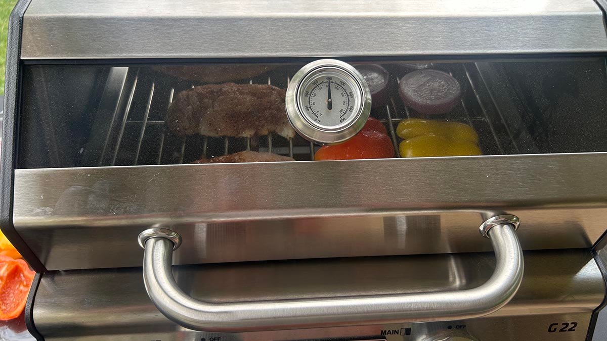 Looking through the viewing window on the Monument Grills G22 Stainless Tabletop Propane Grill