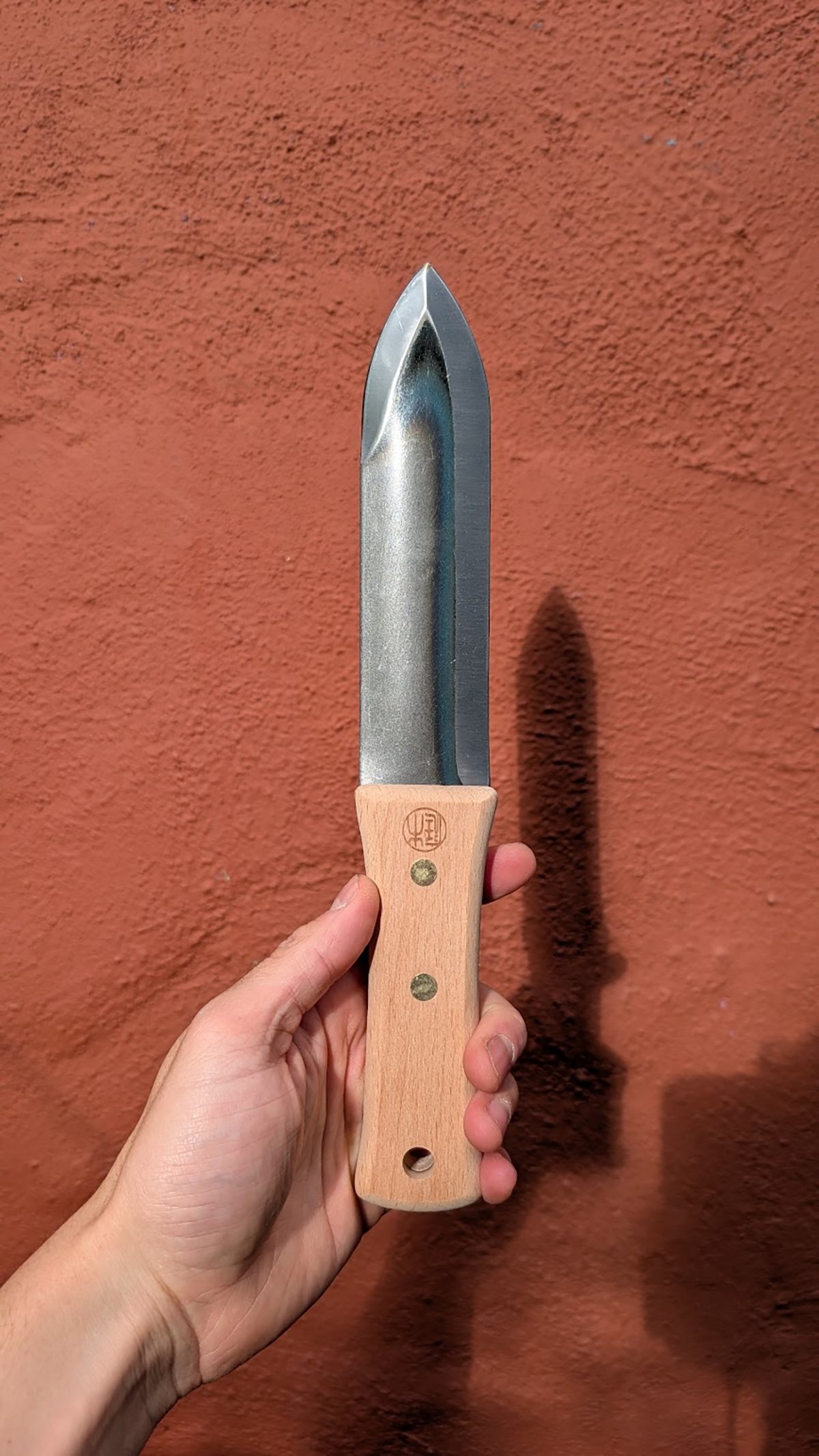 A person holding the Niwaki Hori Hori Knife during testing