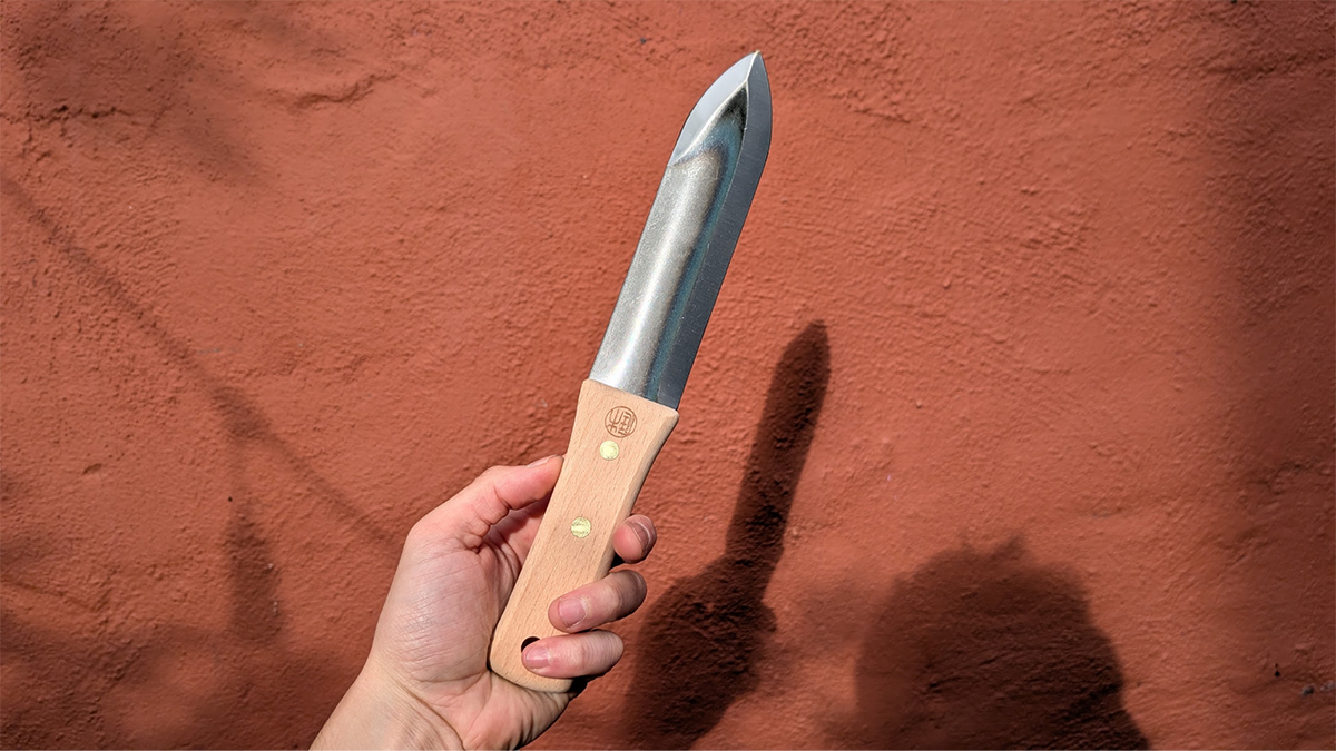 A person holding the Niwaki Hori Hori Knife during testing