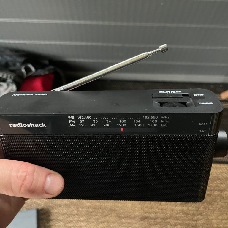 A peson holding the RadioShack prepper essentials radio outdoors