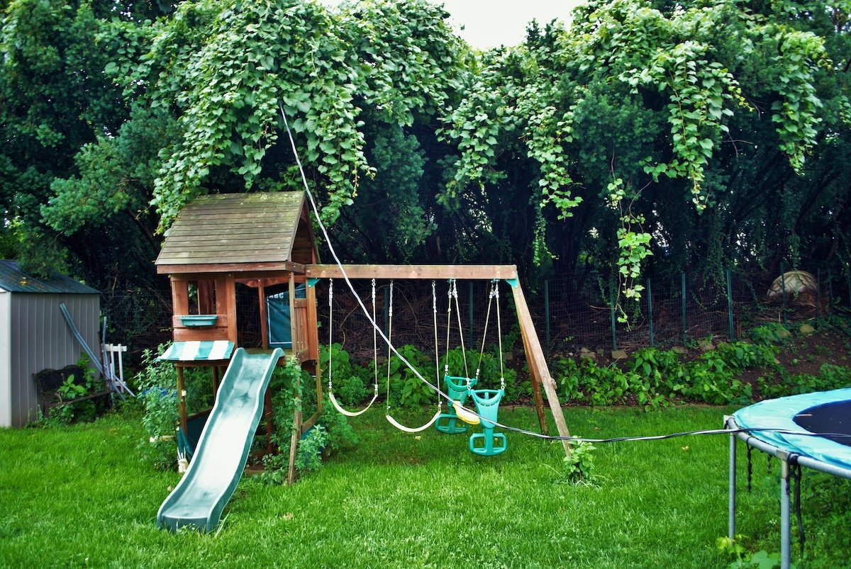 Dangerous live downed power line draped across trampoline and backyard playground