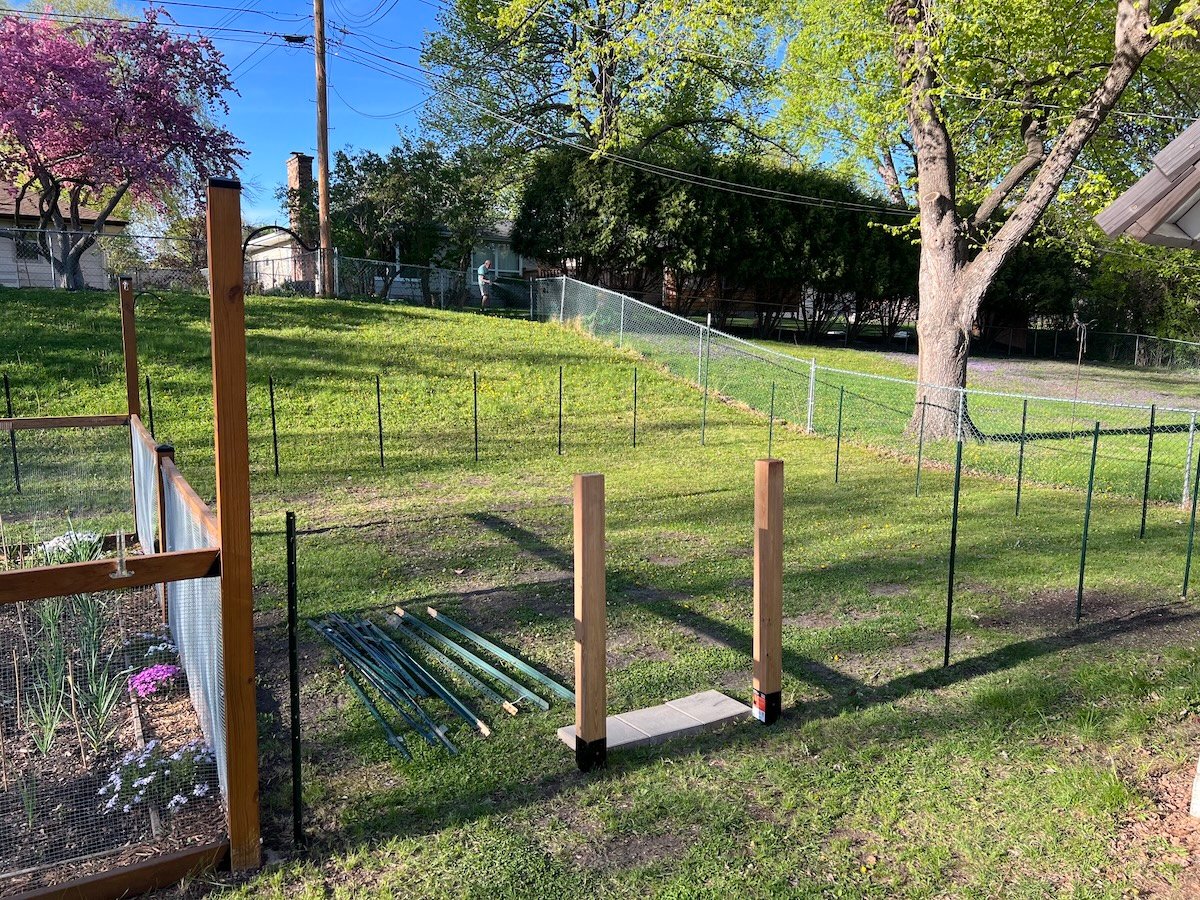 Two wood posts set in a yard with steel spikes.